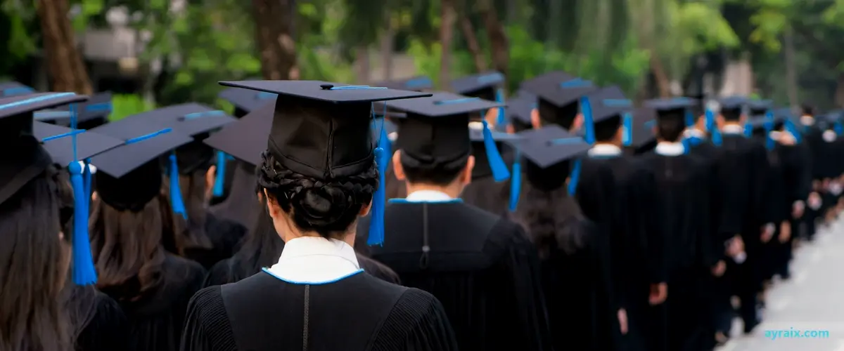 Rear view of a large uniform crowd of university graduates in black gowns lined up at a graduation ceremony