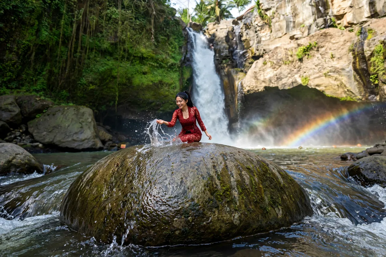 Tiny Zara on a rock at Tegenungan Waterfall